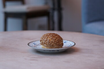A choux cream puff bakery pastry on the plate.