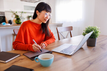 Web designer drawing using drawing pad while working remotely from home