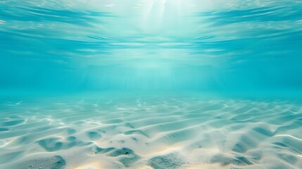 Sunlight Penetrating Clear Blue Water Revealing Sandy Ocean Floor with Gentle Ripples and Sparkling Waves