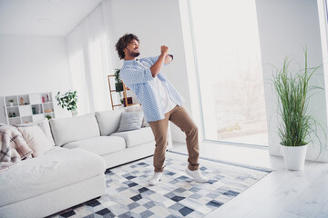 Photo of cool good mood man wear checkered shirt staying home having fun indoors house apartment...