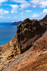 The magnificent volcanic cliffs of the Atlantic Ocean coast near the lighthouse El Faro de la Entallada, Fuerteventura, Canary Islands
