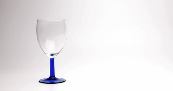 Eingiessen von Weisswein in Glas, l&auml;uft &uuml;ber