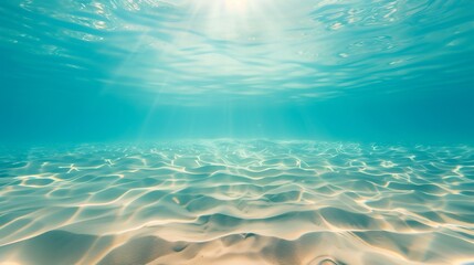 Sunlight Penetrating Clear Blue Water Revealing Sandy Ocean Floor with Gentle Ripples and Sparkling Waves