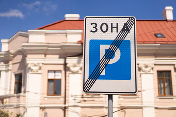 A prominent no parking zone sign is displayed in front of a classic building with intricate architectural details. Sign stands out as a definitive indication of parking regulations in the area.