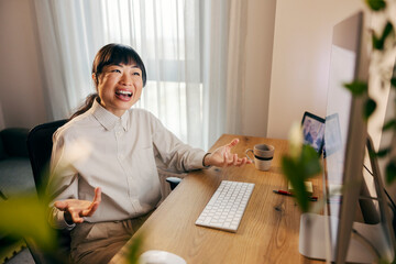An asian businesswoman sitting at home office and having conference call with business partners.