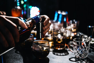 Bartender Mixing a Cocktail with Coffee Liqueur at a Busy Bar