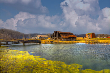 Barn by a Pond.  A rustic old barn in rural Missouri, with a collapsing roof sits beside a tranquil pond, reflecting the bright sky above.  © Larry 