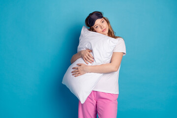 Photo of sweet lovely cute girl wear white stylish pajama hands hold soft pillow isolated on blue...