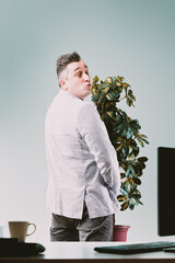Rude man is urinating in an office plant since he knows he will