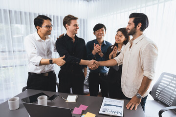 Diverse group of office employee worker shake hand after making agreement on strategic business...