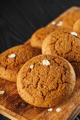 oatmeal cookies with a glass of milk on a black wooden rustic background