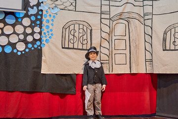 portrait of a latin boy at a school event for the independence day in Argentina with a gentleman's costume and a background decoration