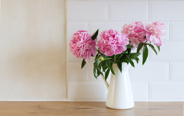 Floral composition, vase with peonies . White wall background. Scandinavian interior room design. Selective focus. Spring flowers. Spring background. A place for your text.