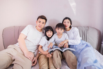 A family of four in bed in the bedroom