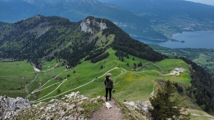 Overlooking hiker at peak of green rolling hills
