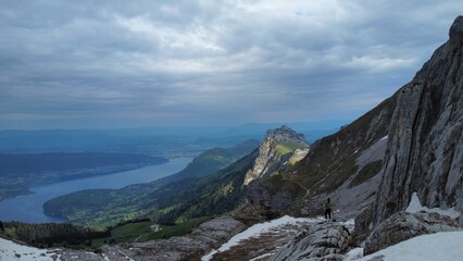 Person hiking in mountains looking down at lake
