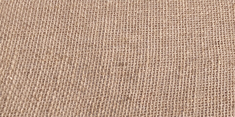 Linen fabric clothing close-up as a background for posters and banner. Brown color hessian sack cloth pattern. abstract background and texture for design.