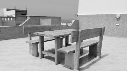 Table and benches on the veranda in black and white