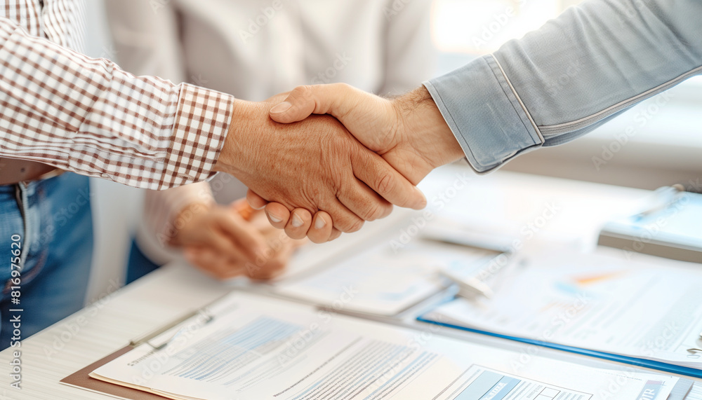 Aufkleber a close-up image of a financial advisor and a client shaking hands at the end of a successful meetin