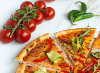 vegetarian pizza with cheese, tomato, pepper and avocado in white wooden desk.Top view