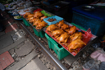 A whole cooked chicken, richly browned and enticing, displayed at a local market, inviting customers with its savory aroma and traditional appeal.
