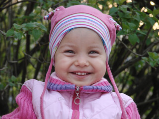 Little adorable smiling girl in spring outdoors.