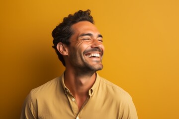 Portrait of a satisfied man in his 30s laughing on soft brown background