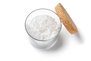 Single glass bowl with white sea salt flakes isolated on white background close up