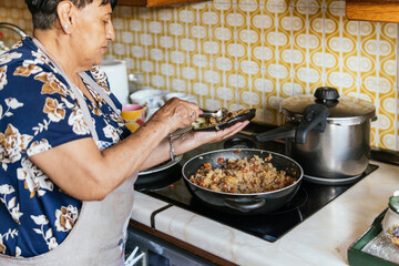 Elderly woman preparing meal in kitchen