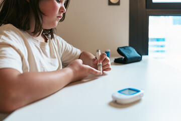 Young girl checking blood sugar levels for diabetes