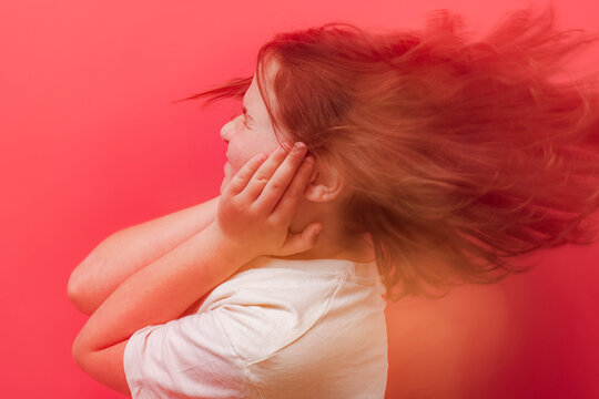 Young child feeling dizziness with hands on head against red background