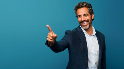 Smiling Man in a Blue Blazer Pointing to the Side with Enthusiasm, Exuding Confidence and Joy Against a Blue Background