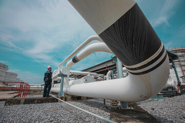 Male worker inspection at steel long pipes and pipe elbow in station oil factory during refinery...