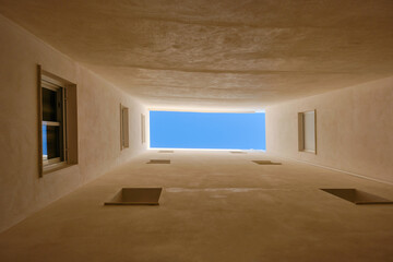 View to the piece of blue sky from the bottom of the  well yard. Yard-well in the city. Spain,...
