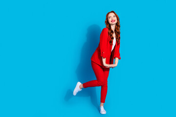 Photo of stunning gorgeous glad girl wear red trendy clothes look empty space isolated on blue...