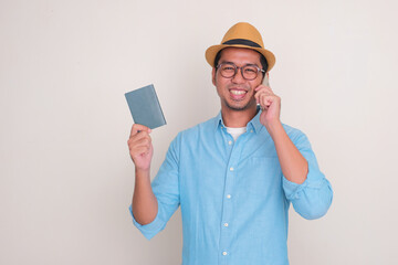 Adult Asian man smiling happy when calling and holding passport