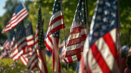 A patriotic display of American flags fluttering in the wind at a Memorial Day ceremony.