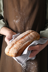 Woman holding one freshly baked bread, closeup