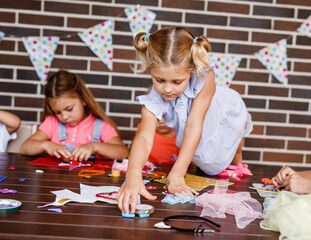 Little girls do needlework and crafts in the summer outdoors