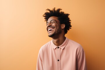 Portrait of a content afro-american man in his 20s laughing isolated on pastel or soft colors background