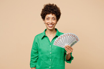 Young woman of African American ethnicity wear green shirt casual clothes hold in hand fan of cash...