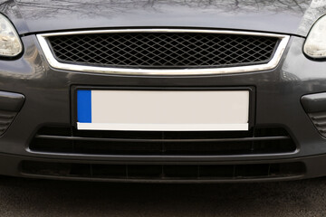 Car with vehicle registration plate outdoors, closeup