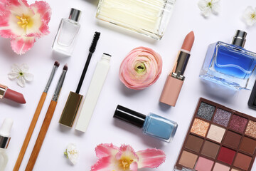 Flat lay composition with different makeup products and beautiful spring flowers on white background