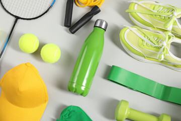 Different sports equipment on light grey background, flat lay