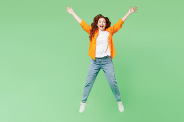 Full body young ginger happy woman she wear orange shirt white t-shirt casual clothes jump high...
