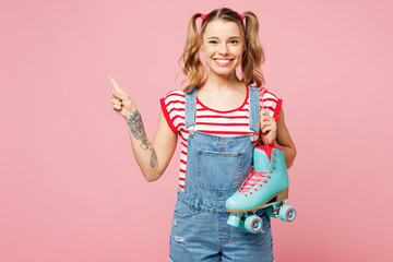 Young smiling happy woman wear red t-shirt denim overalls casual clothes hold rollers point index...