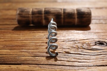 One corkscrew on wooden table, closeup view