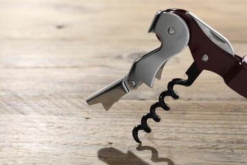 One corkscrew (sommelier knife) on wooden table, closeup. Space for text