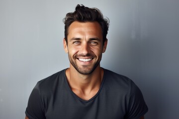 Fototapeta premium Portrait of a merry man in his 30s smiling at the camera isolated on minimalist or empty room background