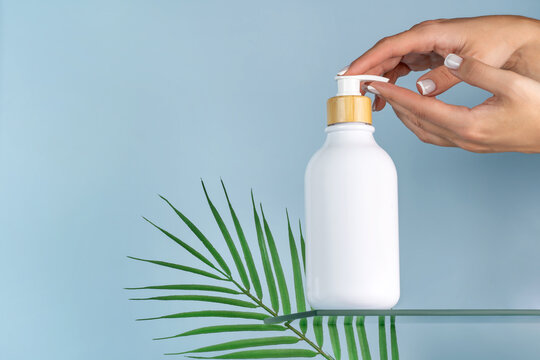 Woman's hand with cosmetic bottle mockup